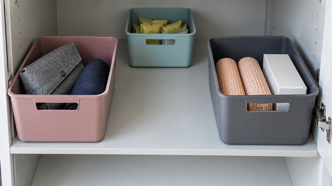 Rose and charcoal bins positioned at the front of a deep shelf, leaving a clear central path to an aqua container at the back.