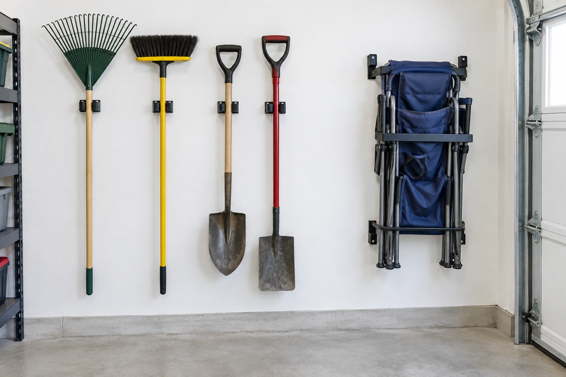 Wall-mounted tool holders with rakes brooms and shovels standing upright beside a rack holding a folded camping chair with clear floor space below