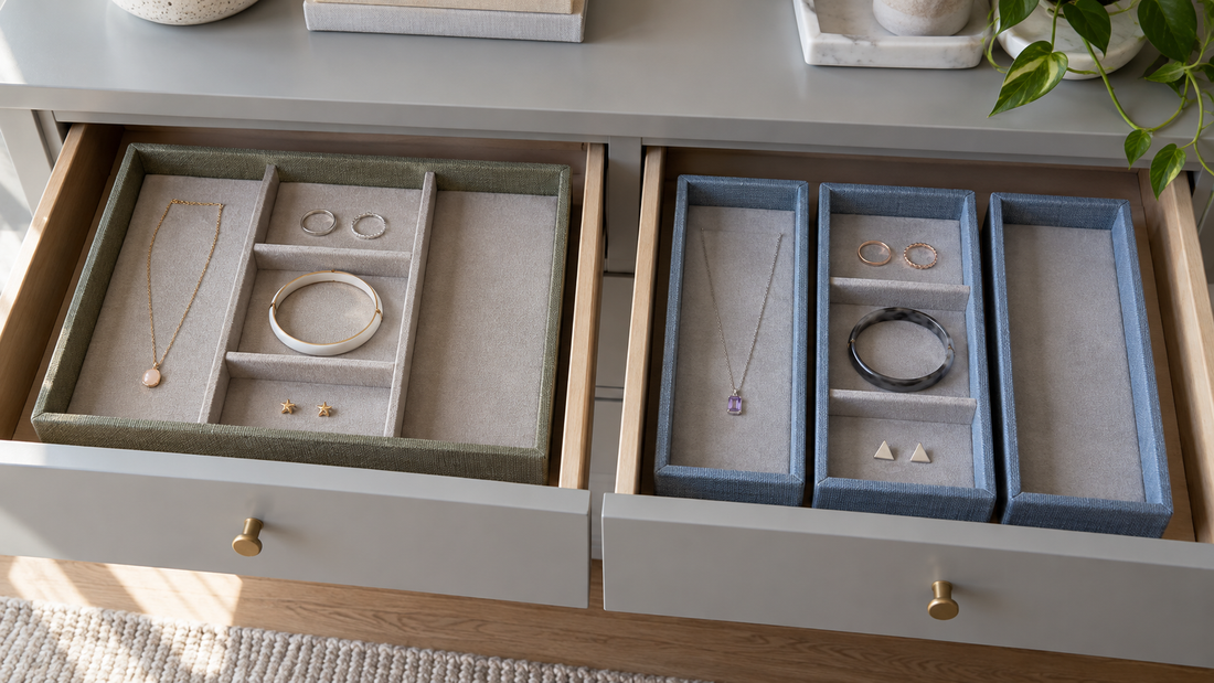 One large olive-gray jewelry tray and three separate blue trays arranged in adjacent open dresser drawers.