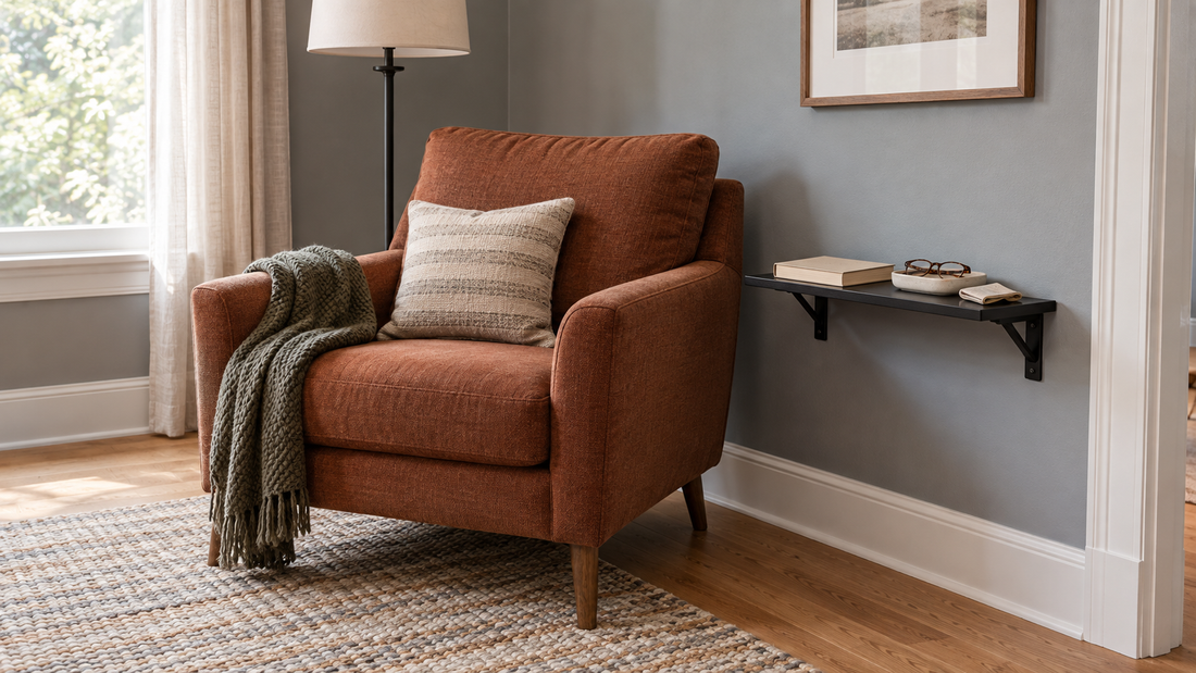 A wall shelf beside a reading chair keeps a book and reading glasses within easy reach.