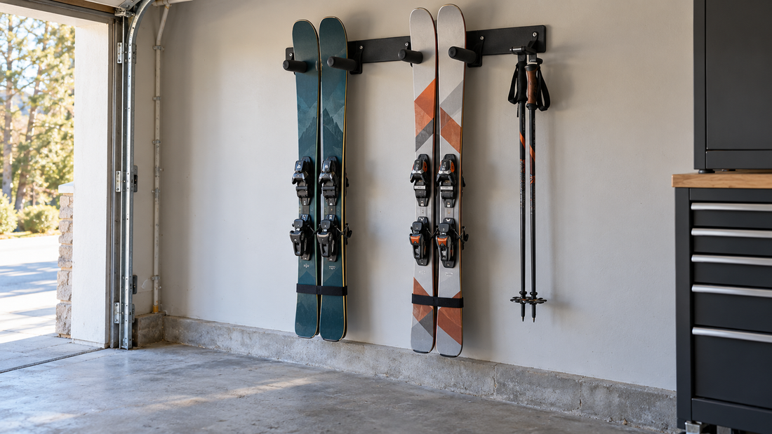 Two pairs of skis and ski poles hang on a wall-mounted garage rack, leaving the floor clear.